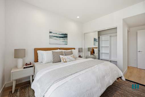 A bedroom with a large bed and a painting on the wall.