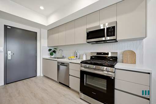 A modern kitchen with a black fridge, stove, and microwave.