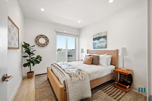 A bedroom with a large bed and a view of the city.