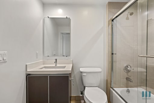 Bathroom with Shower Bath with Glass Door and Vanity Cabinet Storage