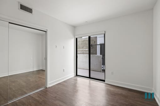 Bedroom with Balcony Access and Mirrored Closet
