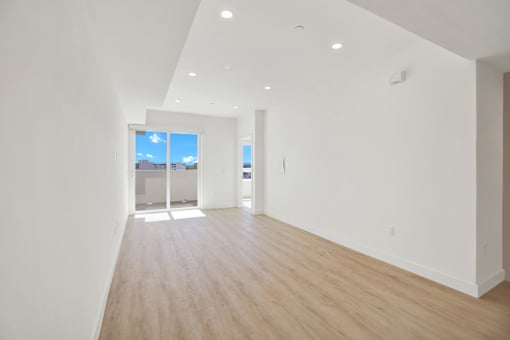 A long, empty room with a view of the sky through a window.
