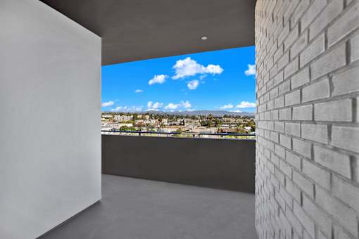 A white wall with a view of the cityscape outside.