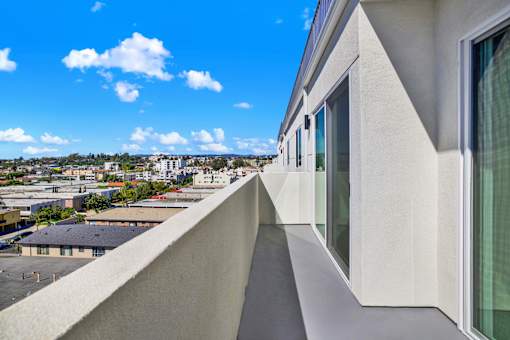 A white building with a balcony overlooking a cityscape.