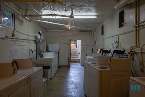 A dirty industrial kitchen with lots of white appliances.