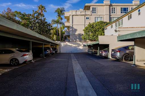 A street view of a residential area with cars parked on both sides.