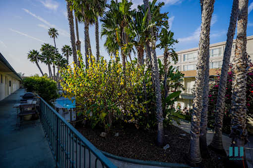 A balcony with a railing and a view of a building and trees.