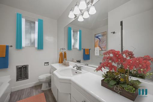 A bathroom with a white sink and a large mirror.