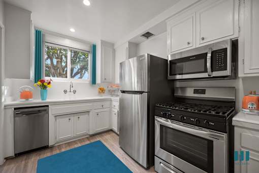 A modern kitchen with stainless steel appliances and white cabinets.