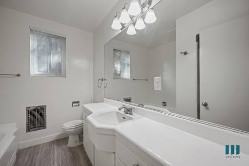 A white bathroom with a toilet, sink, and bathtub.