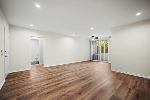 a living room with white walls and wood floors