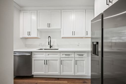 a kitchen with white cabinets and stainless steel appliances