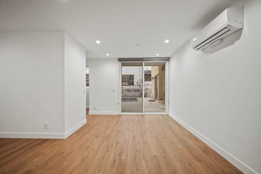 a living room with white walls and a sliding glass door