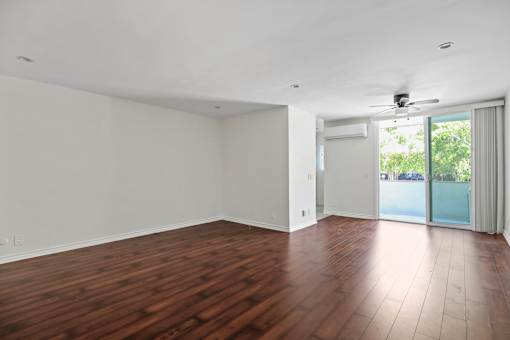 an empty living room with wood floors and a sliding glass door
