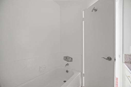 a white bathroom with a tub and a shower