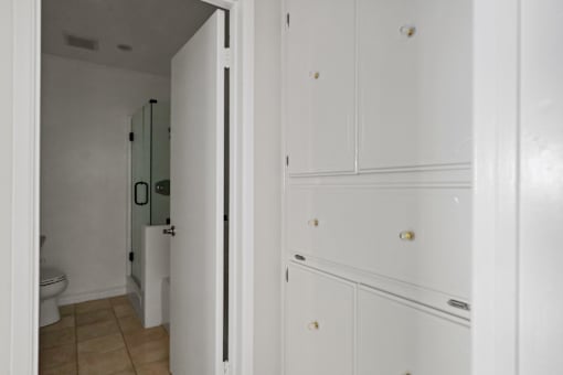 a bathroom with white cabinets and a toilet