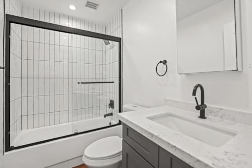 a white bathroom with a shower and a sink and a toilet