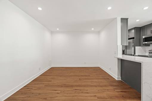 an empty living room with white walls and wood flooring