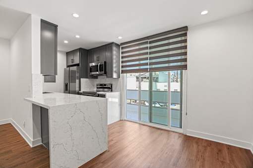 a kitchen with a marble island and a door to a balcony