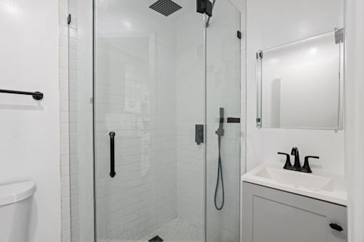 a white bathroom with a shower and a sink