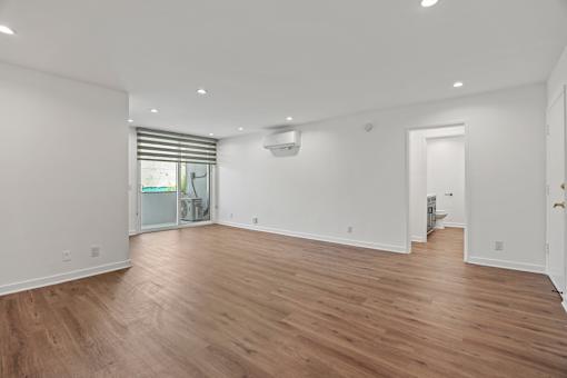 an empty living room with white walls and wood floors