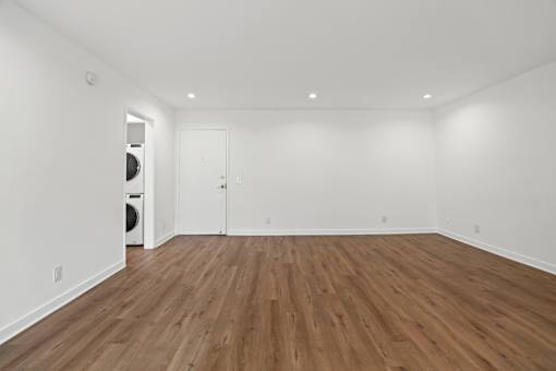 a living room with white walls and wood floors