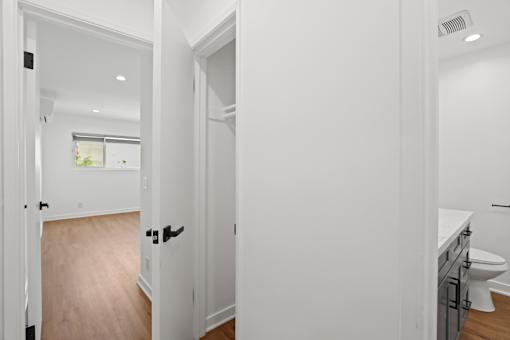 a bathroom and a living room with white walls and wood floors