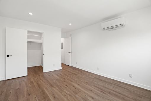 an empty living room with white walls and wood flooring