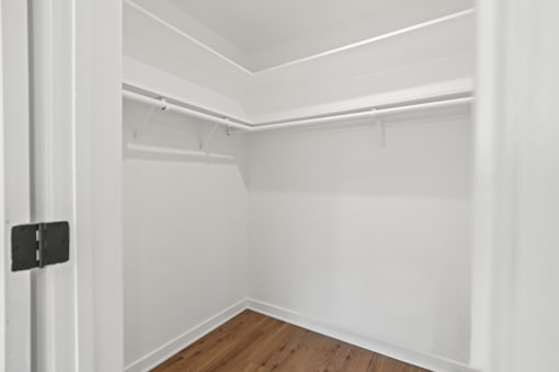 an empty room with white walls and a wood floor