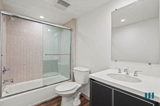 Bathroom with Bathtub with Glass Door and Vanity Cabinet Storage