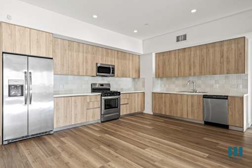 A modern kitchen with wooden cabinets and stainless steel appliances.