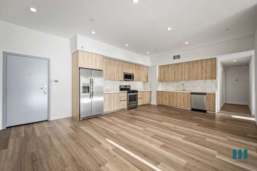 A kitchen with wooden floors and stainless steel appliances.