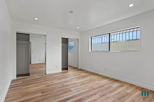 Bedroom with Two Closets, Vinyl Flooring, and Recessed Lighting