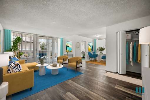 A living room with a yellow couch and a blue rug.