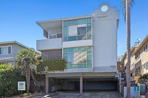A modern house with a white facade and large windows.
