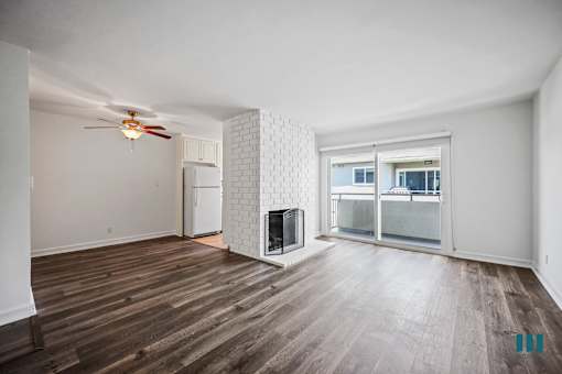 Open-Concept Dining and Living Room with Vinyl Flooring, Fireplace, and Patio