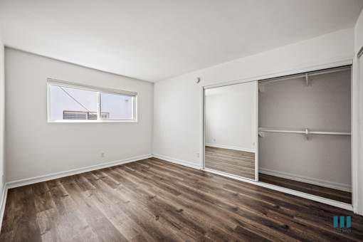 Bedroom with Large-Size Mirrored Closet and Vinyl Flooring
