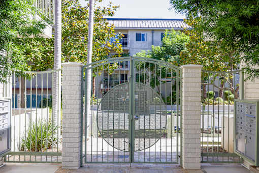 a gate with a house behind it behind a fence