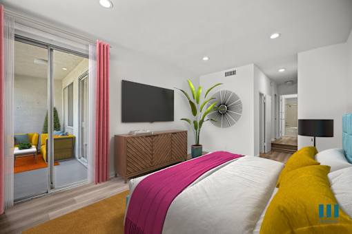 A bedroom with a large bed and a flat screen TV mounted on the wall.