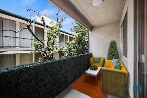 A small balcony with a table and chairs.