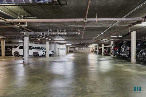 A parking garage with multiple cars parked.