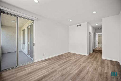 A room with wooden flooring and white walls.