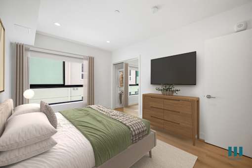 A bedroom with a bed, dresser, and a flat screen TV mounted on the wall.
