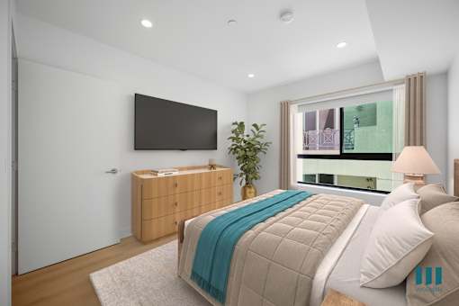 A bedroom with a large bed and a flat screen TV mounted on the wall.