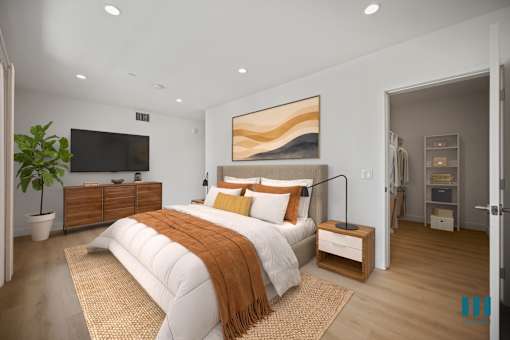 A bedroom with a large bed and a painting on the wall.