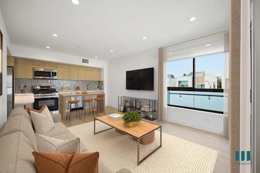 A modern living room with a large couch, a coffee table, and a television.