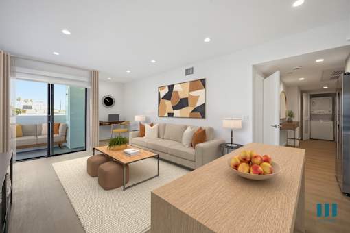 A modern living room with a wooden table and a bowl of fruit on it.