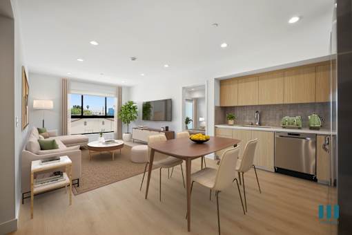 A modern kitchen and living room with a dining table and chairs.