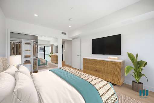 A bedroom with a large bed and a flat screen TV mounted on the wall.
