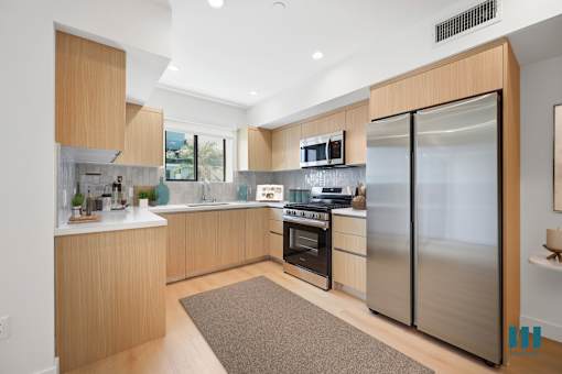 A modern kitchen with wooden cabinets and stainless steel appliances.